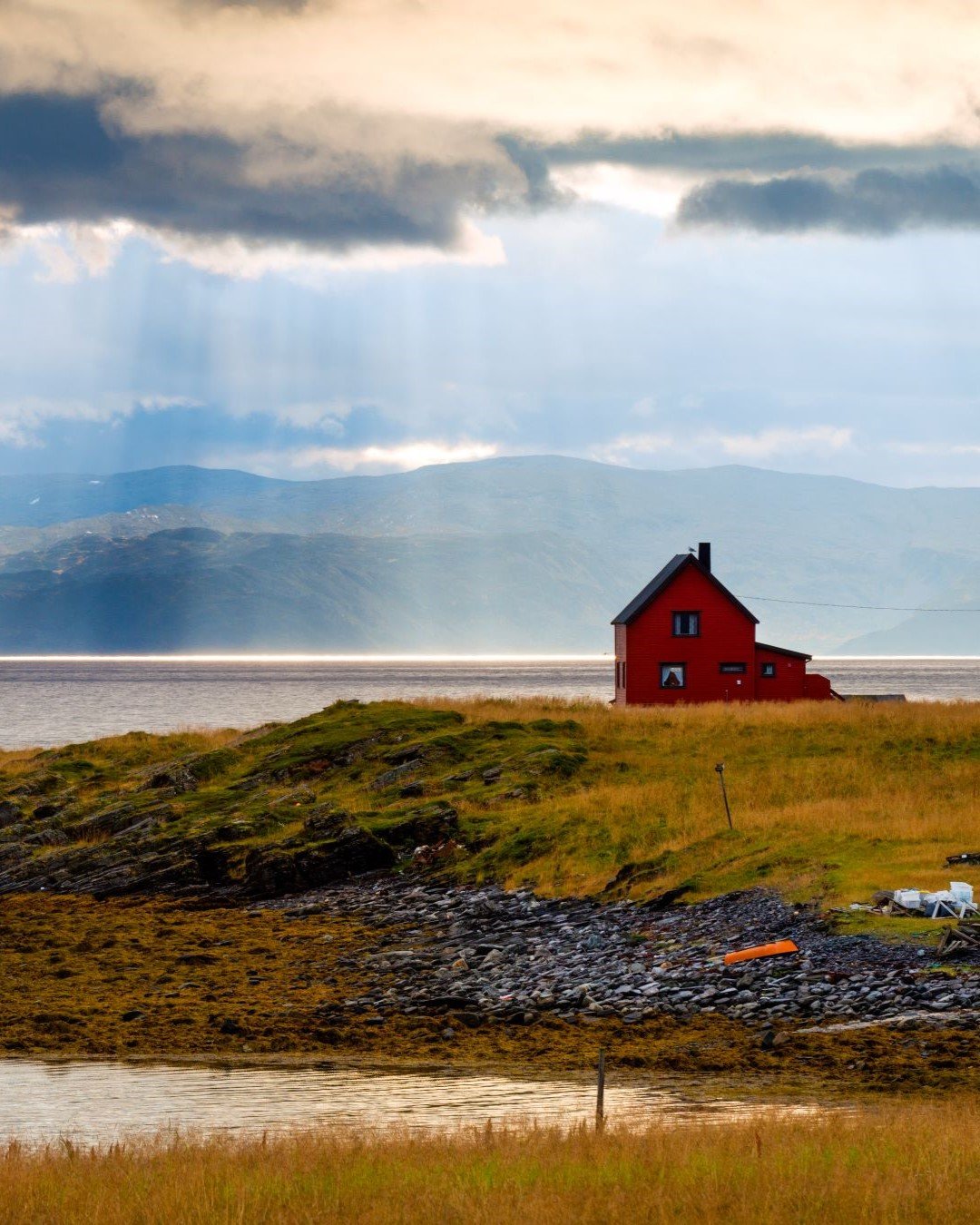 Fjorparti med enslig hus ved fjorden.