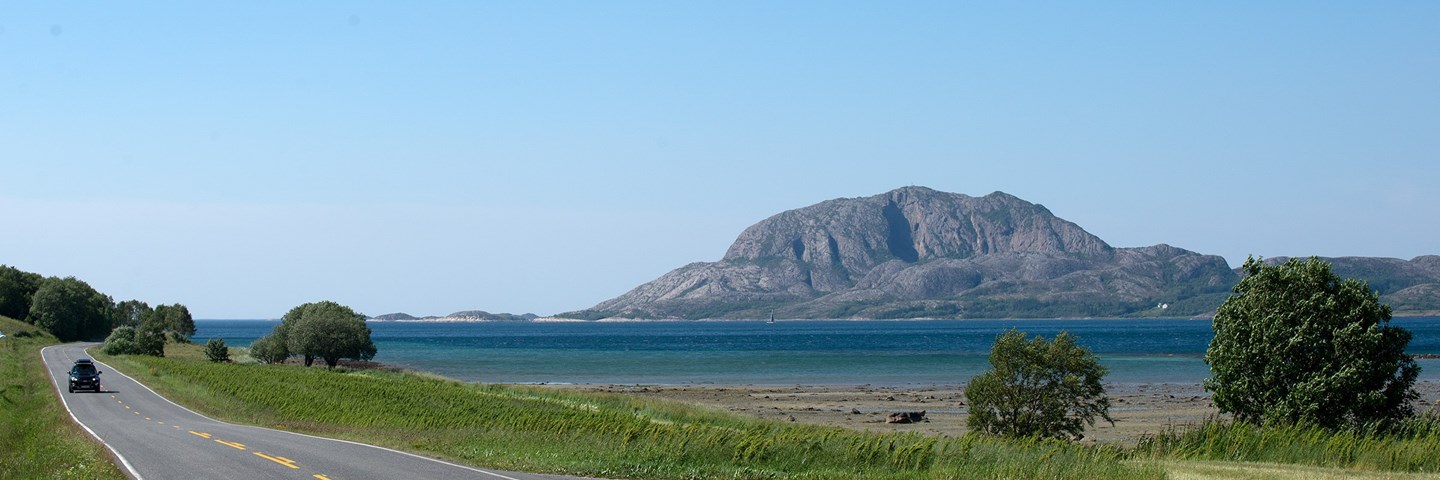 Turistveg med hav og fjellet Torghatten i det fjerne.