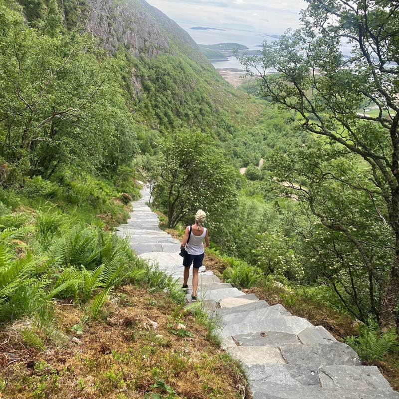 Person auf Steinstufen vom Torghatten hinunter.