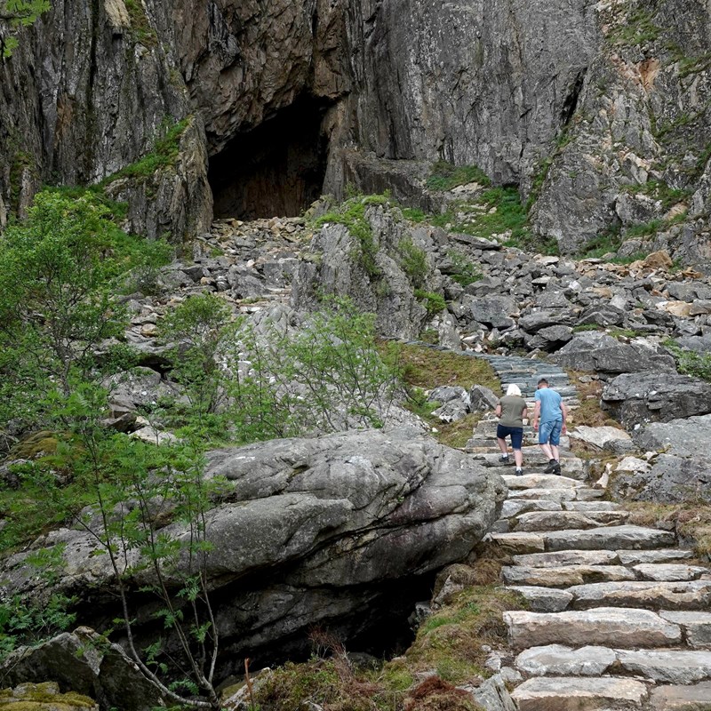 To personer på tur opp til Torghatten.