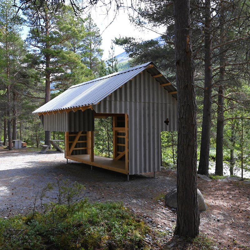 Sykkelskjul med hvileplass i skogen.