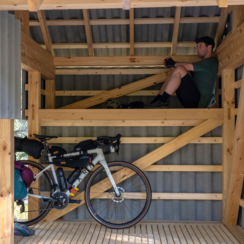 Fahrradschuppen mit Rastplatz im Wald.